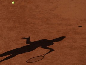 FILE - In this Saturday, May 30, 2015 file photo a tennis player casts a shadow during a match at the French Open tennis tournament at the Roland Garros stadium in Paris. Four people are in French custody on suspicion of fixing matches for an Armenian based in Belgium believed behind an illegal gambling syndicate suspected of fixing hundreds of matches.