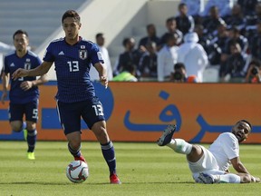 Japan's forward Yoshinori Muto, left, gets away from Saudi Arabia's defender Mohammed Al-Burayk during the AFC Asian Cup round of 16 soccer match between Japan and Saudi Arabia at the Sharjah Stadium in Sharjah, United Arab Emirates, Monday, Jan. 21, 2019.