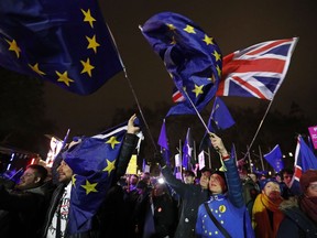 Anti-Brexit demonstrators react after the results of the vote on British Prime Minister Theresa May's Brexit deal were announced in Parliament square in London, Tuesday, Jan. 15, 2019. British lawmakers have rejected Prime Minister Theresa May's Brexit deal by a huge margin, plunging U.K. politics into crisis 10 weeks before the country is due to leave the European Union. The House of Commons voted 432 -202 on Tuesday against the deal struck between Britain's government and the EU in November.