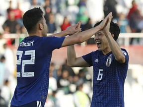 Japan's defender Maya Yoshida, left, and Japan's defender Wataru Endo celebrate after the AFC Asian Cup round of 16 soccer match between Japan and Saudi Arabia at the Sharjah Stadium in Sharjah, United Arab Emirates, Monday, Jan. 21, 2019. Japan won the match 1-0.