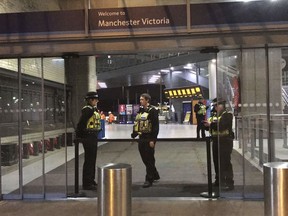 Police at Victoria Station in Manchester, England, late Monday Dec. 31, 2018 after a man had stabbed three people. Two commuters - a man and woman in their 50s - were taken to hospital with knife injuries and a British Transport Police (BTP) officer was stabbed in the shoulder. Police said a man was arrested on suspicion of attempted murder and remains in custody.