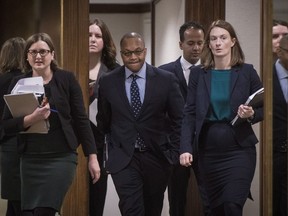 Justice Michael H. Tulloch, centre, makes his way to a press conference to discuss the report from the Independent Street Checks Review looking at Ontario's regulation on police street cheeks at the Chelsea Hotel in Toronto, Friday, January 4, 2019.