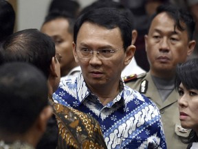 FILE - In this May 9, 2017, file photo, then Jakarta Governor Basuki "Ahok" Tjahaja Purnama, center, talks to his lawyers after his sentencing hearing at a court in Jakarta, Indonesia, Tuesday, May 9, 2017.  The polarizing Christian politician whose campaign comments ignited protests that were the largest in Muslim-majority Indonesia in years was freed Thursday, Jan. 24, 2019 after serving nearly two years in prison for blasphemy.