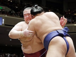 In this Tuesday, Jan. 15, 2019, photo, grand champion Kisenosato, left, is pushed by Tochiozan at the New Year Grand Sumo Tournament in Tokyo. Kisenosato, the only Japanese wrestler at sumo's highest rank, has decided to retire after three straight losses at the tournament. (Kyodo News via AP)
