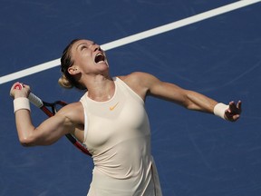 FILE - In this Aug. 27, 2018, file photo, Simona Halep, of Romania, serves to Kaia Kanepi, of Estonia, during the first round of the U.S. Open tennis tournament, in New York.  No. 1-ranked Halep returns to competitive tennis this week at the Sydney International unsure if her back injury has fully healed.