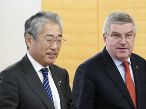 FILE - In this Nov. 30, 2018, file photo, International Olympic Committee (IOC) President Thomas Bach, right, escorts Japanese Olympic Committee (JOC) President Tsunekazu Takeda during an IOC Executive Board meeting in Tokyo. France's financial crimes office says International Olympic Committee member Takeda is being investigated for corruption related to the 2020 Tokyo Olympics. The National Financial Prosecutors office says Takeda, the president of the Japanese Olympic Committee, was placed under formal investigation for "active corruption" on Dec. 10.