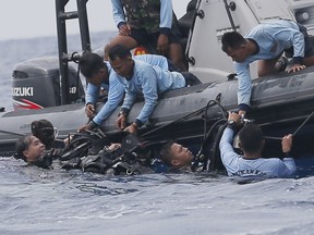 FILE - In this Oct. 30, 2018, file photo, Indonesian navy frogmen emerge from the water during a search operation for the victims of the crashed Lion Air plane in the waters of Tanjung Karawang, Indonesia. A search effort has located the cockpit voice recorder of the Lion Air jet that crashed into the Java Sea in October 2018, an Indonesian official said Monday, Jan. 14, 2019, in a possible boost to the accident investigation. Ridwan Djamaluddin, a deputy maritime minister, told reporters that the agency investigating the crash that killed 189 people had informed the ministry about the discovery.