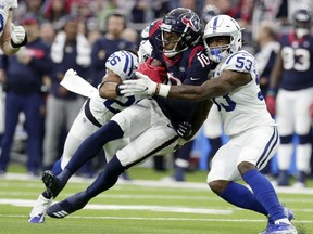 Houston Texans wide receiver DeAndre Hopkins (10) is hit by Indianapolis Colts strong safety Clayton Geathers (26) and linebacker Duke Ejiofor (53) after making a catch during the first half of an NFL wild card playoff football game, Saturday, Jan. 5, 2019, in Houston.