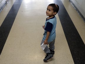In this Friday, Jan. 11, 2019, photo, Maria Orbelina Cortez's 3-year-old son, Julio, walks in the hallway of the Catholic Charities shelter in McAllen, Texas. Orbelina says she decided to flee El Salvador after her husband attacked her and caused a pan of hot oil to fall, scalding the child and leaving a scar on his head.