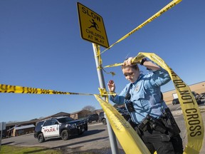 Texas City Police officer S. Garcia ties crime scene tape to a sign outside of the Pointe Ann Apartments in Texas City, Texas, Friday, Jan. 4, 2019,  where multiple children were found dead and a woman was shot. Texas City Police said Junaid Hashim Mehmood surrendered and was taken into custody in connection to the crime Thursday night.