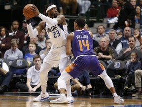 Dallas Mavericks guard Wesley Matthews (23) looks to pass around Phoenix Suns guard De'Anthony Melton (14) during the first half of an NBA basketball game, Wednesday, Jan. 9, 2019, in Dallas.