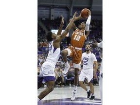 Texas guard Kerwin Roach II (12) shoots against TCU center Russell Barlow (34) as guard Alex Robinson (25) looks on during the first half of an NCAA college basketball game in Fort Worth, Texas, Wednesday, Jan. 23, 2019.