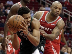 Milwaukee Bucks forward Giannis Antetokounmpo, left, protects his rebound from Houston Rockets forward PJ Tucker, right, during the first half of an NBA basketball game Wednesday, Jan. 9, 2019, in Houston.