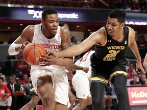 Houston forward Breaon Brady (24) gets a rebound as Wichita State forward Jaime Echenique (21) reaches in during the first half of an NCAA college basketball game Saturday, Jan. 12, 2019, in Houston.