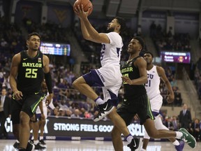 TCU guard Alex Robinson, center, drives past Baylor guard Jared Butler, right, and forward Tristan Clark, left, in the first half of an NCAA college basketball game, Saturday, Jan. 5, 2019, in Fort Worth, Texas.