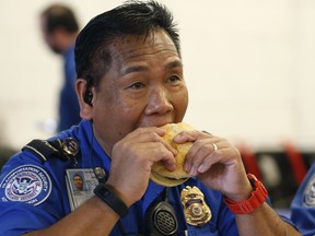 TSA employee Hill Dalde eats a hamburger during lunch at Salt Lake City International Airport, Wednesday, Jan. 16, 2019, in Salt Lake City. In Salt Lake City, airport officials treated workers from the TSA, FAA and Customs and Border Protection to a free barbecue lunch as a gesture to keep their spirits up during a difficult time.