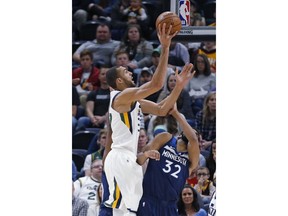 Utah Jazz center Rudy Gobert (27) shoots as Minnesota Timberwolves center Karl-Anthony Towns (32) defends during the first half of an NBA basketball game Friday, Jan. 25, 2019, in Salt Lake City.