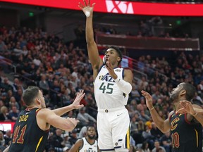 Utah Jazz guard Donovan Mitchell (45) shoots as Cleveland Cavaliers' Ante Zizic (41) and Alec Burks (10) defend during the first half in an NBA basketball game Friday, Jan. 18, 2019, in Salt lake City.