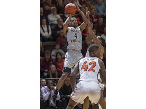 Wake Forest guard Torry Johnson (4) shoots over Virginia Tech guard Ty Outlaw (42) during the first half of an NCAA college basketball game Saturday, Jan. 19, 2019, in Blacksburg, Va.