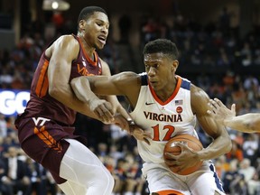 Virginia Tech forward Kerry Blackshear Jr. , left, tries to block Virginia guard De'Andre Hunter (12) during the first half of an NCAA college basketball game in Charlottesville, Va., Tuesday, Jan. 15, 2019.