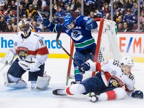 Vancouver Canucks' Tyler Motte (64) crashes into the net behind Florida Panthers goalie Roberto Luongo (1) after having the puck taken away by Bogdan Kiselevich (55), of Russia, during the second period of an NHL hockey game in Vancouver, on Sunday January 13, 2019.