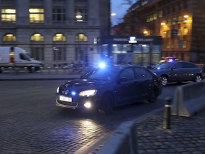 Police in unmarked cars arrive at the Justice Palace during the trial of Mehdi Nemmouche in Brussels, Thursday, Jan. 10, 2019. Mehdi Nemmouche is accused of shooting dead four people at a Jewish museum in Belgium in 2014.