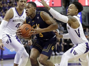 California's Paris Austin (3) drives between Washington's Matisse Thybulle (4) and David Crisp in the first half of an NCAA college basketball game Saturday, Jan. 19, 2019, in Seattle.
