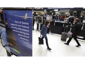 A sign near a TSA security checkpoint states the Port of Seattle's support for federal government workers, Friday, Jan. 25, 2019, in Seattle. Yielding to mounting pressure and growing disruption, President Donald Trump and congressional leaders on Friday reached a short-term deal to reopen the government for three weeks while negotiations continue over the president's demands for money to build his long-promised wall at the U.S.-Mexico border.