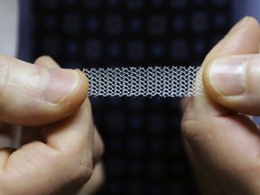 In this Dec. 20, 2018, photo, Dr. Jeffrey Clemons, a pelvic reconstructive surgeon, holds a sample of transvaginal mesh used to treat pelvic floor disorders and incontinence in women as he poses for a photo in Tacoma, Wash. Clemons helped draft a letter to state Attorney General Bob Ferguson that was signed by more than 60 Washington state surgeons, arguing that Ferguson's consumer-protection lawsuit against Johnson & Johnson and its Ethicon Inc. subsidiary over the mesh products might scare patients away from the best treatment options.