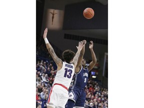 Loyola Marymount guard James Batemon (5) shoots while defended by Gonzaga guard Josh Perkins (13) during the first half of an NCAA college basketball game in Spokane, Wash., Thursday, Jan. 17, 2019.