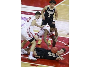 Purdue's Grady Eifert (24) passes the ball away from Wisconsin's Ethan Happ (22) and Khalil Iverson during the first half of an NCAA college basketball game Friday, Jan. 11, 2019, in Madison, Wis.