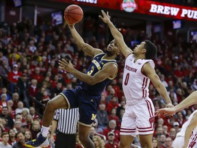 Michigan's Zavier Simpson (3) shoots against Wisconsin's D'Mitrik Trice (0) during the first half of an NCAA college basketball game Saturday, Jan. 19, 2019, in Madison, Wis.