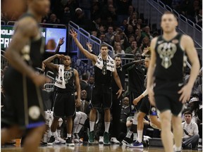 Milwaukee Bucks players react from the bench after a 3-point basket against the Charlotte Hornets during the second half of an NBA basketball game Friday, Jan. 25, 2019, in Milwaukee.