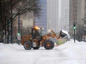 A plow removes snow along West Wisconsin Avenue at North 8th Street in Milwaukee on Monday, Jan. 28, 2019. Heavy snow and gusting winds created blizzard-like conditions Monday across parts of the Midwest, prompting officials to close hundreds of schools, courthouses and businesses as forecasters warn that dangerously cold weather is right behind the snowstorm.