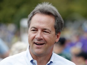 FILE - In this Aug. 16, 2018, file photo, Montana Gov. Steve Bullock walks down the main concourse during a visit to the Iowa State Fair in Des Moines, Iowa. Former Vice President Joe Biden and several nationally known senators are commanding most of the attention in Democrats' early presidential angling, but there are several governors and mayors, including Bullock, eyeing 2020 campaigns, as well.