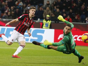 AC Milan's Krzysztof Piatek, left, scores his side's opening goal during an Italian Cup quarter-final soccer match between AC Milan and Napoli at the San Siro stadium, in Milan, Italy, Tuesday, Jan. 29, 2019.