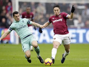 Arsenal's Granit Xhaka tackles West Ham's Samir Nasri, right, during the English Premier League soccer match between West Ham United and Arsenal at London Stadium in London, Saturday, Jan. 12, 2019.