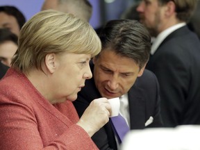 German Chancellor Angela Merkel talks with Italian Prime Minister Giuseppe Conte over a coffee at the annual meeting of the World Economic Forum in Davos, Switzerland, Wednesday, Jan. 23, 2019.