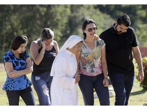 Friends and relatives attend the burial of Vale SA employee Edgar Carvalho Santos, victim of the collapsed dam in Brumadinho, Brazil, Tuesday, Jan. 29, 2019.  Officials said the death toll was expected to grow "exponentially," since no had been rescued alive since Saturday.