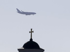Russian President Vladimir Putin's plane seen as it flies over a church before its landing at the Belgrade's Nikola Tesla Airport, Serbia, Thursday, Jan. 17, 2019. Putin arrives in Serbia on Thursday for his fourth visit to the Balkan country since 2001.