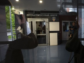 In this photo taken on Tuesday, May 24, 2016, journalists wait at the a door of Russia's national drug-testing laboratory in Moscow, Russia. World Anti-Doping Agency experts have started the process of copying data from a Moscow laboratory that could implicate numerous Russian athletes in past drug cases.
