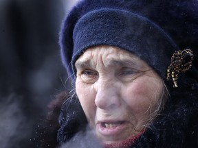 A woman reacts during prayers at the scene of the collapsed apartment building in Magnitogorsk, a city of 400,000 people, about 1,400 kilometers (870 miles) southeast of Moscow, Russia, Wednesday, Jan. 2, 2019. The building's pre-dawn collapse on Monday came after an explosion that was believed to have been caused by a gas leak.