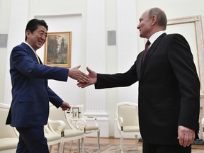 Russian President Vladimir Putin, right, greets Japanese Prime Minister Shinzo Abe prior their talks in the Kremlin in Moscow, Russia, Tuesday, Jan. 22, 2019.