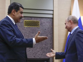 FILE - In this file photo taken on Dec. 5, 2018, Russian President Vladimir Putin, right, and his Venezuelan counterpart Nicolas Maduro gesture prior to their talks at the Novo-Ogaryovo residence outside in Moscow, Russia. The crisis in Venezuela may have reached a new boiling point, but the geopolitical fault lines look familiar. Russia, China and Iran have thrown their support behind embattled Maduro, while the U.S., Canada and their allies in Western Europe are backing opposition leader Juan Guaido as interim president.