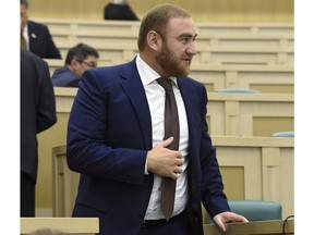 In this photo taken on Wednesday, Sept. 28, 2016, Rauf Arashukov, who represents the Karachaevo-Cherkessiya region in the North Caucasus, stands at the Federation Council, in Moscow, Russia. A Russian lawmaker suspected of contracting two murders was detained on Wednesday at the Russian parliament in front of stunned deputies after he tried to escape but was stopped by the parliament speaker. (Dmitry Dukhanin/Kommersant Photo via AP) RUSSIA OUT