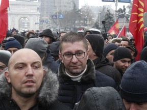 Hristijan Mickoski, center, leader of the opposition VMRO-DPMNE party, arrives to a protest against the change of the country's constitutional name, outside the parliament building prior a session of the Macedonian Parliament in the capital Skopje, Wednesday, Jan. 9, 2019. Macedonian lawmakers are entering the last phase of debate on constitutional changes to rename their country North Macedonia as part of a deal with neighboring Greece to pave the way for NATO membership and eventually joining the European Union.