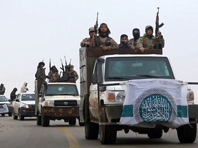 This photo released Dec. 4, 2018 by the al-Qaida-affiliated Ibaa News Agency, shows al-Qaida-linked fighters driving their vehicles during a military drill in northern Syria. It took the al-Qaida-linked militants only few days to capture more than two dozen towns and villages in and around Idlib province, cementing the group's control over an area in northwestern Syria the size of neighboring Lebanon. The push by members of Hayat Tahrir al-Sham, or HTS, is the most serious blow to a September cease-fire for Idlib brokered by Russia and Turkey, and puts tens of thousands of civilians at risk of losing medical support due to a drop in aid from western agencies. (Ibaa News Agency, via AP)