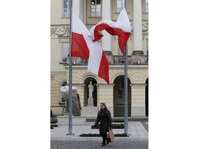 Poland's national flags flying at half-staff in front of the townhall in Warsaw, Poland, Tuesday, Jan. 15, 2019 in a sign of mourning for the slain Gdansk city Mayor Pawel Adamowicz who was knifed down in Gdansk on Sunday during a charity event.