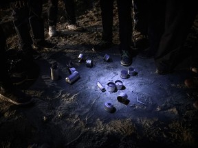 Migrants stand by tear gas canisters they collected that were shot towards the Mexican side by U.S. Border Patrol officers after they attempted to get into the U.S. side to San Diego, Calif., from Tijuana, Mexico, Tuesday, Jan. 1, 2019. Discouraged by the long wait to apply for asylum through official ports of entry, many migrants from recent caravans are choosing to cross the U.S. border wall and hand themselves in to border patrol agents.