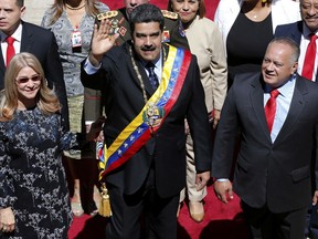 Venezuela's President Nicolas Maduro waves as he arrives with first lady Cilia Flores and Constitutional Assembly President Diosdado Cabello to the National Assembly where he will give his annual address to the nation, before members of the Constitutional Assembly in Caracas, Venezuela, Monday, Jan. 14, 2019.